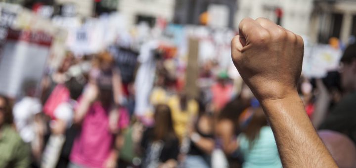 A raised fist of a protestor at a political demonstration