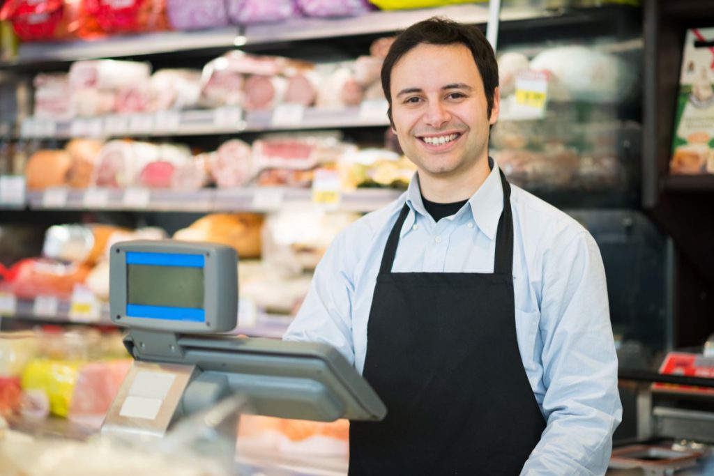 Portrait of a smiling shopkeeper in a grocery store