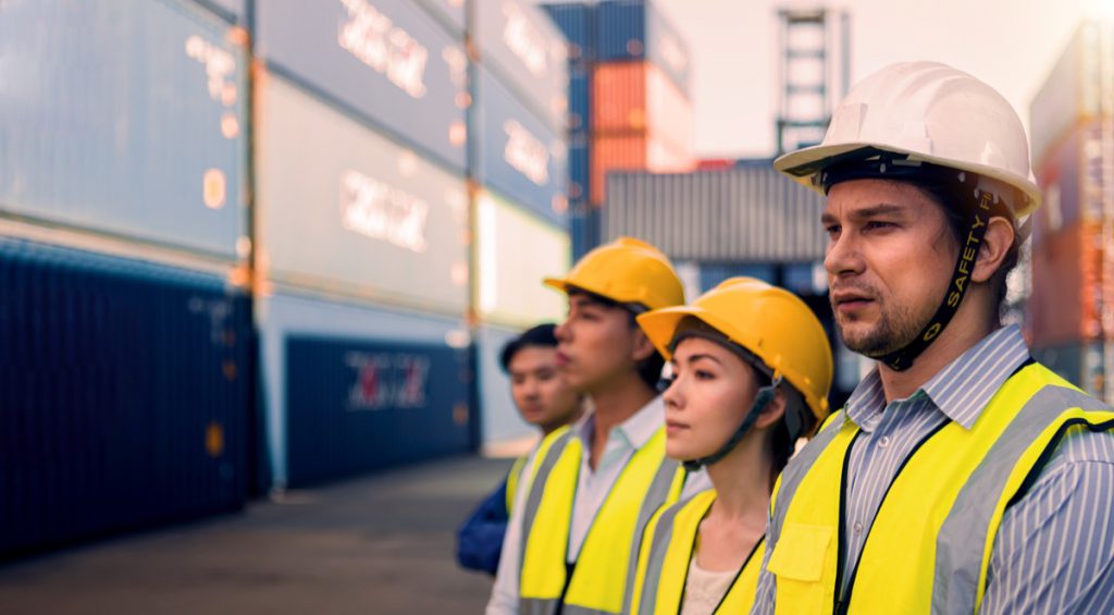 Group of workers standing in container yard; choosing a union concept