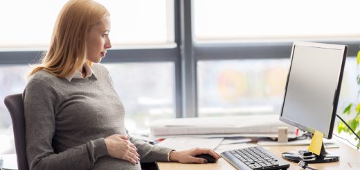 Pregnant woman sitting at her desk in the office; DOL initiatives concept