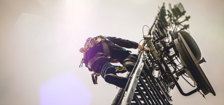 Telecom worker climbing antenna tower; safer working conditions concept