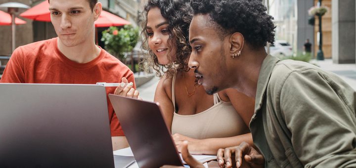 three people reading digital newsletter